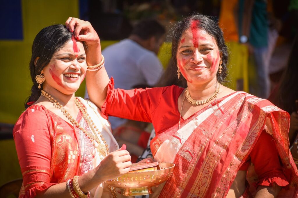 Women celebrate the traditional Sindoor Khela festival with joy and vibrant colors in Siliguri, India.